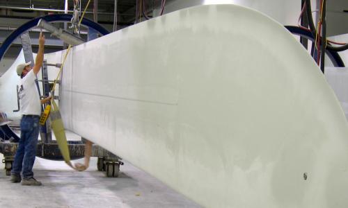 Two people working on a wind turbine blade.