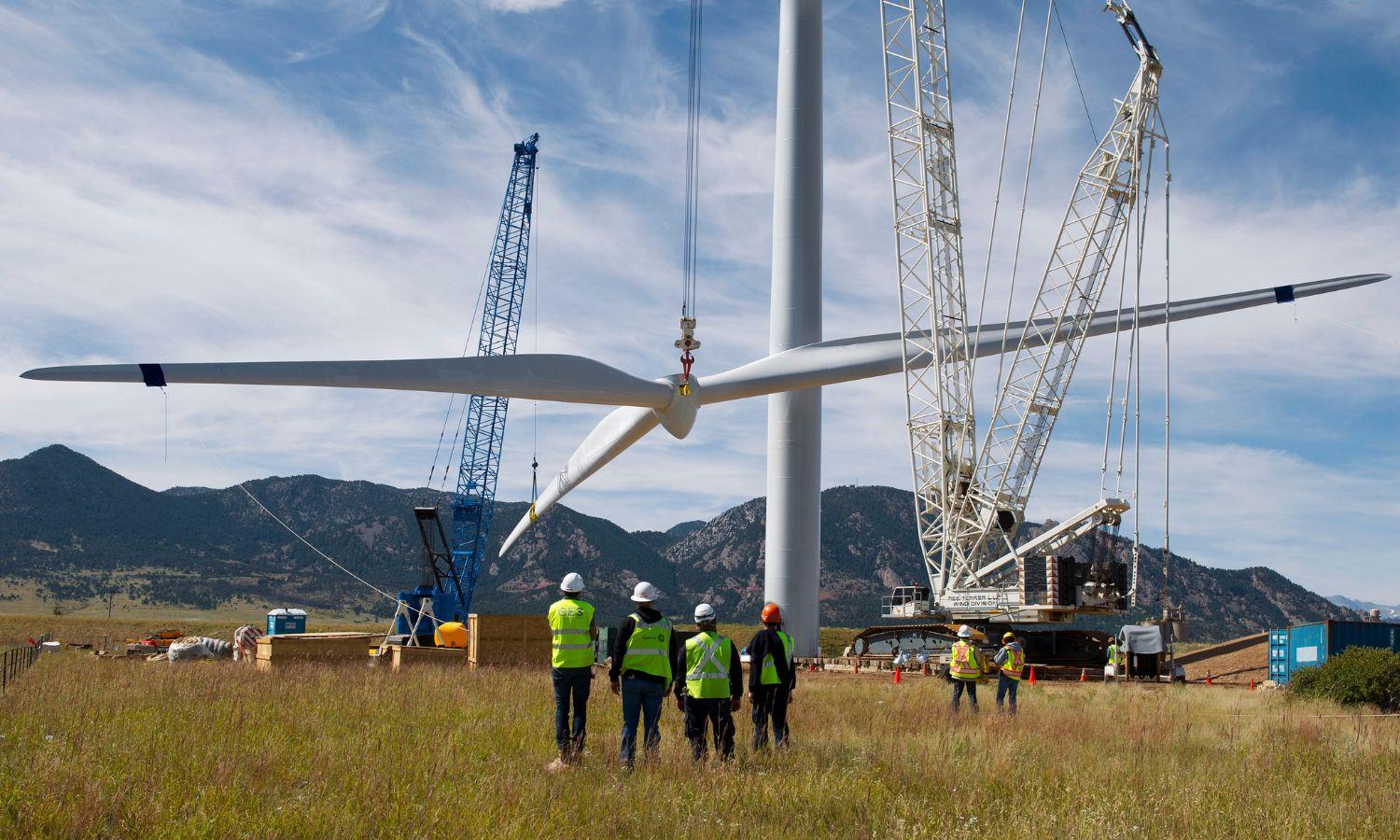 A wind turbine being assembled by a crew of workers.