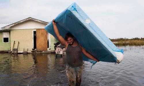 A person hauling a mattress during a flood