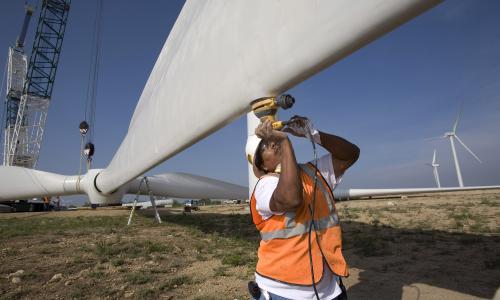 Worker helping to construct wind turbine blades.